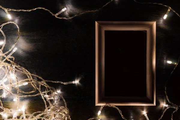 Siyah arka planda açık renkli bir çelenk olan ahşap çerçeve