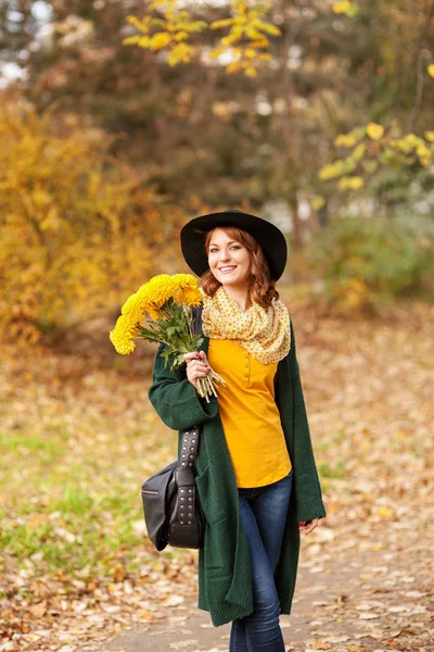 Mujer joven con ramo de flores silvestres — Foto de Stock