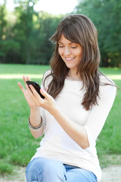 Ung kvinna som använder mobiltelefon — Stockfoto