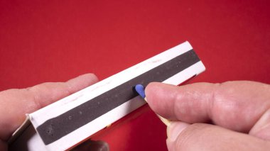 Bir kibrit ve bir kutu tutuyor ve onu yakmak üzereyim.