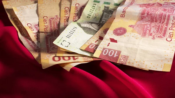 Meksika pesolarının fotoğrafı, kırmızı arkaplanda banknotlar.