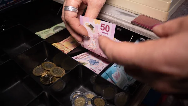Olgun kadın kasada para saklıyor, Meksika pezosu.