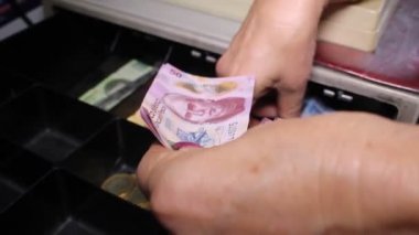 Olgun kadın kasada para saklıyor, Meksika pezosu.