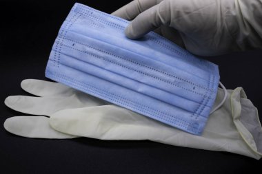 Sterilize cerrahın eldivenleri ve mavi ağız koruyucuları.