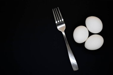 Siyah arka planda hazırlıksız beyaz tavuk yumurtası.