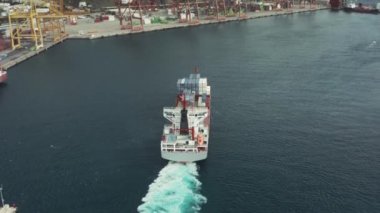 Deniz konteynerli kargo gemisi bir kargo limanı terminalinde gelir.