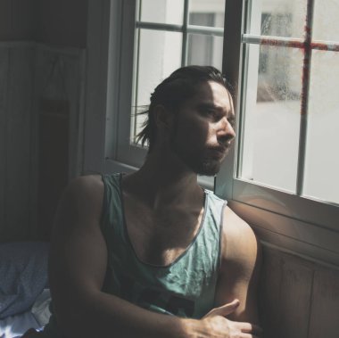 Model, genç adam spor yaptıktan sonra güneş ışığı yüzüne 2 numaralı pencereden bakıyor.