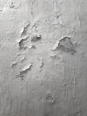 Eski duvar yüzeyinin klasik arka planı. Eski beyaz alçı. Beyazlatıcı parçalar halinde dökülüyor. Dikey yönelim. 