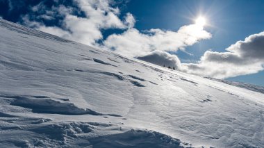 Baharda dağlar karla kaplı, parlak bahar güneşinde.