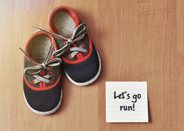 Çocuk, spor ayakkabı ve ahşap arka plan üzerinde etiket uyarı mektubu