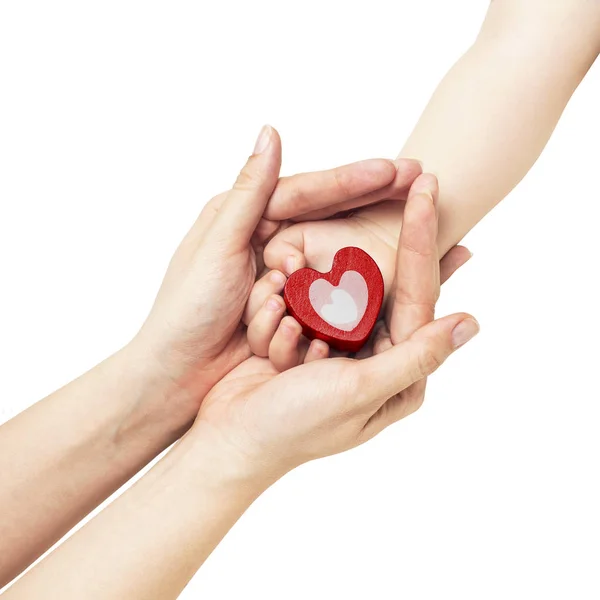 Hand of the mother holding the hand of a small child with a red heart — Stock Photo, Image