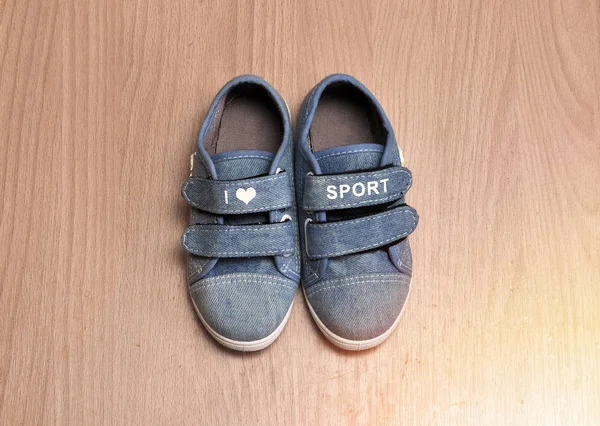 Zapatillas deportivas de bebé sobre fondo de madera. amor por el deporte — Foto de Stock