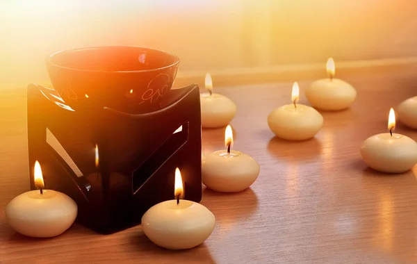 Bruciatore a olio con candele su fondo di legno — Foto Stock