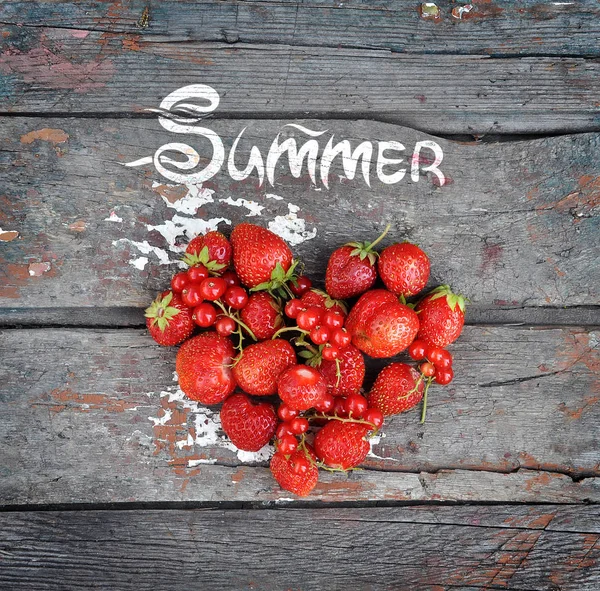 Palabra verano sobre un fondo de madera y corazón de bayas — Foto de Stock