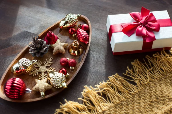 Cozy rustic Christmas background on a wooden background with a gift and Christmas decor items in a homely atmosphere.Top view, flat lay.Holidays, New Year 2020 present concept.