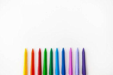 Beyaz arka planda renkli kalemler dalgası. Moda renkleri, düz yatış, kopyalama alanı. 