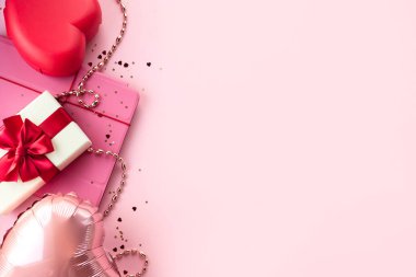 Sevgililer Günü kompozisyonu, arka plan, kalp, tablet, kırmızı kurdeleli hediye kutusu, pembe arka plan. 14 Şubat tebrik kartı