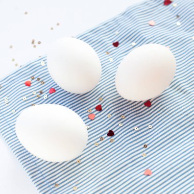 Konfeti kalpli süslü yumurtalarla süslü Paskalya beyazı arka plan. Boşluk kare biçimine sahip düz uzanmış 