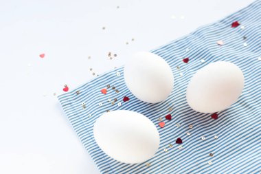 Konfeti kalpli süslü yumurtalarla süslü Paskalya beyazı arka plan. Kopyalama alanı olan düz 