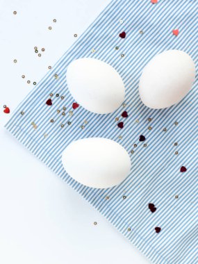 Konfeti kalpli süslü yumurtalarla süslü Paskalya beyazı arka plan. Kopyalama alanı olan düz 