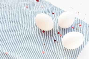 Konfeti kalpli süslü yumurtalarla süslü Paskalya beyazı arka plan. Kopyalama alanı olan düz 