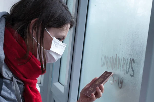 戴面具的女人在机场看着窗户 上面有带有俄罗斯护照的验尸官文字 验尸官检疫的概念Mers Cov Novel Coronavirus 2019 Ncov — 图库照片