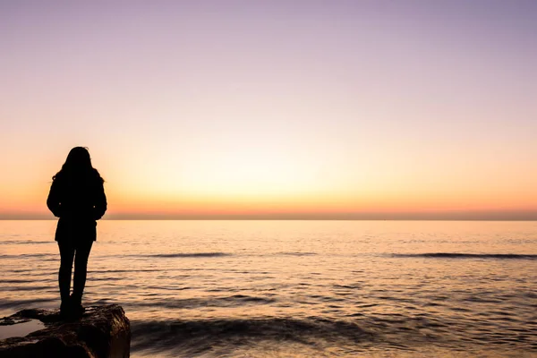 Niña observando el amanecer en la playa de Oropesa, Valencia, España Fotos De Stock Sin Royalties Gratis