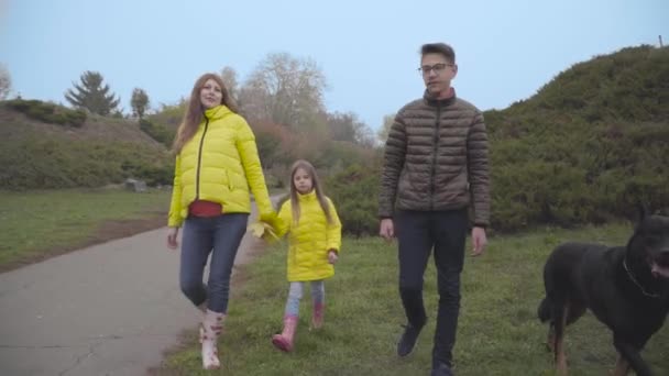 Blanke Familie Wandelen Het Najaarspark Met Hun Grote Zwarte Hond — Stockvideo