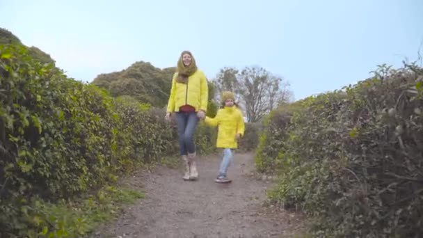 Menina Caucasiana Feliz Pulando Longo Arbustos Verdes Com Sua Mãe — Vídeo de Stock