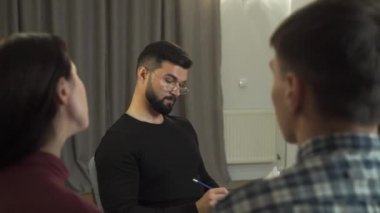 Sakallı psikolog olarak kocasıyla konuşan çekici beyaz kadın onlara arka plandan bakıyor. Müşteri problemlerini çözmekle ilgilenen profesyonel psikolog. Çift terapisi oturumu.
