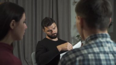 Kafkasyalı genç çift Rorschach mürekkep lekeleri vizyonlarını tartışıyor. Siyah saçlı profesyonel erkek psikolog tepkilerini analiz ediyor. Çift terapisi, psikolojik analiz..