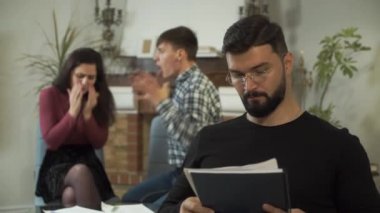 Beyaz erkek psikolog, müşterileri arka planda bağırırken gözlüğünü çıkarıp iç çekiyor. Kızgın koca karısına bağırıyor, kadın ağlıyor. Stresli çiftler terapisi.