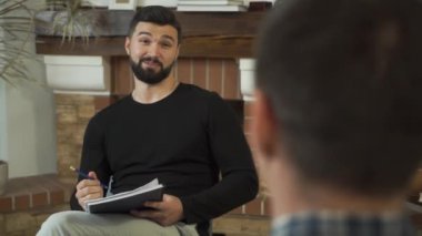 Kafkas psikoloğunun konuşup gülümsediği bir fotoğraf. Karşısında oturan hastaya profesyonel hikâyeler anlatıyor. Bireysel terapi, psikolojik sorunları çözmek..