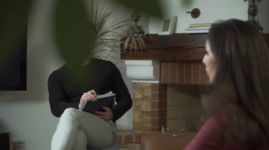 Sinirli hastasını dinleyen konsantre bir beyaz erkek psikoloğun portresi. Duygusal olarak el kol hareketi yapan ve sorunlarını anlatan genç bir kadının omzunun üstünden ateş etmek. Kişisel terapi..