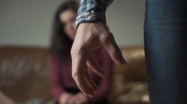 Ön planda elini yumruğa sıkıştıran kızgın beyaz bir adam var. Arka planda ağlayan ve başını eliyle tutan genç bir kadın. Aile içi şiddet, zorbalık, sosyal sorunlar.