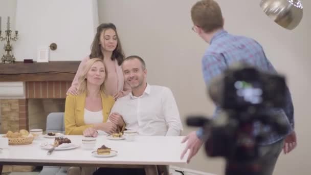Portret van gelukkige mooie familie bijeenkomst en glimlachend naar fotocamera. Jonge roodharige blanke man die fotocamera 's aanpast en bij familie komt. Gedenkwaardige momenten van het leven. — Stockvideo