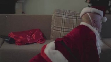 Kanepeye tırmanan son derece sarhoş, Kafkasyalı, Noel Baba kostümlü adam. Tatilden sonra kötü Noel Baba. Alkolizm, depresyon, negatiflik, yalnızlık..