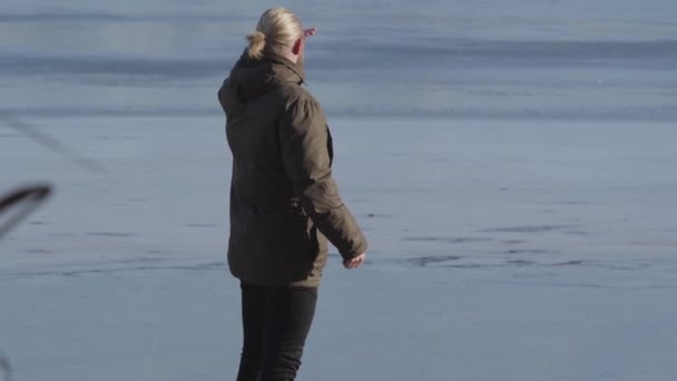 Portret van een zelfverzekerde blonde blanke man die op de oever van het meer staat en hand in hand op het voorhoofd kijkt. Volwassen toerist genietend van de zonnige herfstdag buiten. Vrije tijd, levensstijl, reizen. — Stockvideo