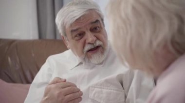 Yakışıklı, yaşlı, beyaz bir adamın, tanınmayan sarışın bir kadınla konuşmasının yakın çekimi. Gülümseyen koca, güzel karısıyla evde sohbet ediyor. Mutluluk, rahatlık, yaşam tarzı, aşk..