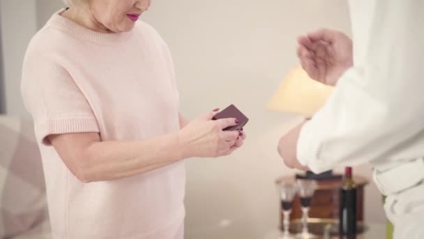 Donna caucasica anziana irriconoscibile che apre il regalo per San Valentino. Una moglie felice che riceve un nuovo anello dal marito. Romanticismo, vacanza, eterno concetto di amore . — Video Stock