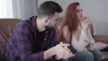 Genç, bulanık, beyaz bir kız ön plandaki üzgün, yakışıklı adama alyansını geri veriyor. Ayrılan çift ilişkisi. Boşanma, sorunlar, evlilik.