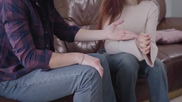 Close-up of young Caucasian man taking wedding ring back from unrecognizable woman. Stressed husband or boyfriend breaking up with girlfriend or wife. Breakup, divorce, drama. — Stock Video