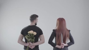 Esmer bir adam ve kızıl saçlı bir kadının birbirlerine bakıp, beyaz arka planda gülümserken görüntüsü. Sarı gül buketi tutan çocuk, kızın elinde büyük bir bıçak var. Evlilik, ilişki..