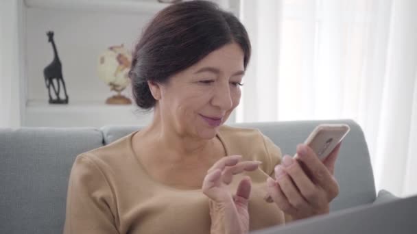 Gros plan d'une femme heureuse et élégante de race blanche utilisant un smartphone. Portrait d'une femme brune d'âge moyen souriante aux yeux bruns surfant sur Internet ou utilisant les médias sociaux. Mode de vie, loisirs, joie . — Video