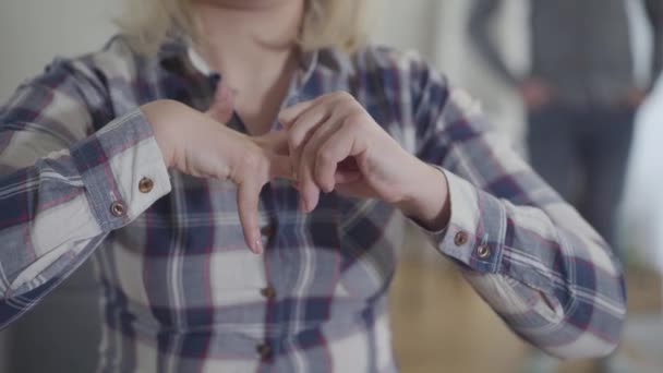 Onherkenbare blanke jonge vrouw die de trouwring afdoet en daarmee haar hand uitstrekt tot wazige echtgenoot. Getrouwde man en vrouw gaan binnen uit elkaar. Scheiding, scheiding, levensstijl. — Stockvideo