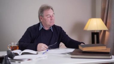 Tükenmiş Kafkasyalı yaşlı adam gözlük takıyor ve belgeler okuyor. İçerideki masada çalışan yaşlı bir emekli. Olgun iş adamı ya da yazar kendini fazla zorluyor. Yaşlanma, yaşam tarzı, yorgunluk..