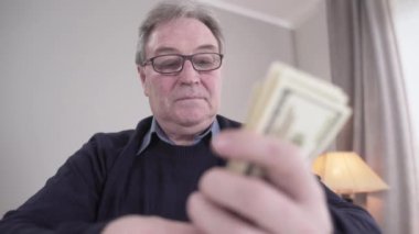 Cash hayranı, gözlüklü, gülümseyen bir grup beyaz adam koyuyor. Ellerinde dolar banknotları tutan zengin emeklilerin portresi. Zenginlik, zenginlik, yaşam tarzı, mutluluk.