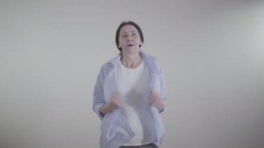 Beyaz kadın portresi. İçeride sıcak hissediyor. Esmer kadın serinlemek için elbiselerini sallıyor ve el sallıyor. Sıcaklık, mevsim, yaşam tarzı.