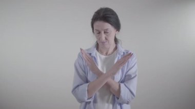 Kafkasyalı ciddi bir kadının portresi el ele tutuşuyor ve başını sallayarak hayır diyor. Reddetme, tasvip etmeme, eleştiri konsepti.