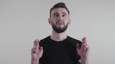 Kafkasyalı stresli bir adamın yakın plan portresi. Parmaklarını çapraz yapıp yukarı bakıyor ve konuşuyor. Genç yakışıklı adam daha yüksek güçlerden yardım istiyor. Sorun, çözüm, yaşam tarzı, endişe.